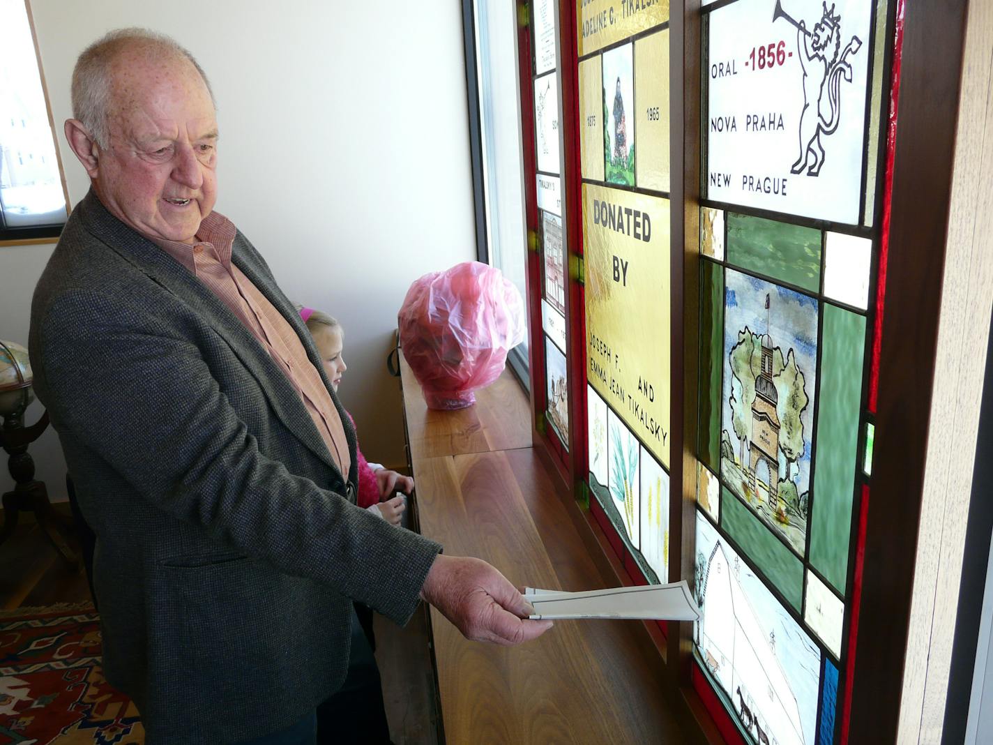 In this December 2008 file photo, Joe Tikalsky shows family members, including granddaughter Olivia, 9, some of the features of the stained glass window in the library room.