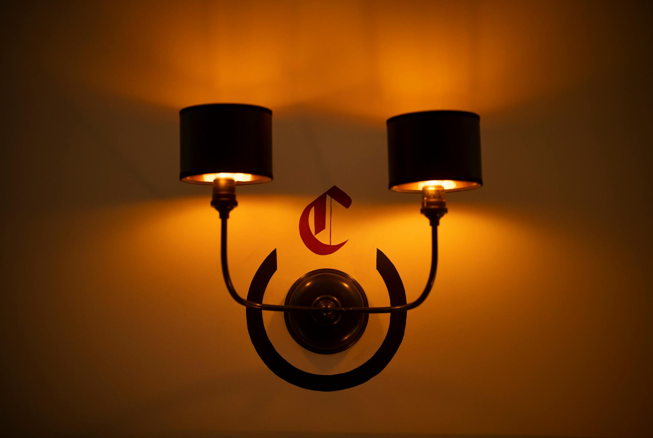 A "C" for Charlie's is stenciled above a wall sconce at Charlie's at the Minneapolis Club.