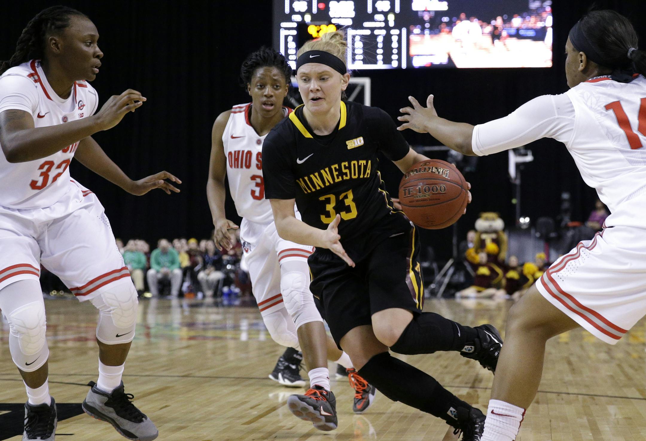Minnesota guard Carlie Wagner (33) drives against Ohio forward Shayla Cooper, left, guard Ameryst Alston, right, and guard Kelsey Mitchell during the first half of an NCAA college basketball game in the quarterfinals of the Big Ten Conference tournament in Hoffman Estates, Ill., on Friday, March 6, 2015. (AP Photo/Nam Y. Huh)