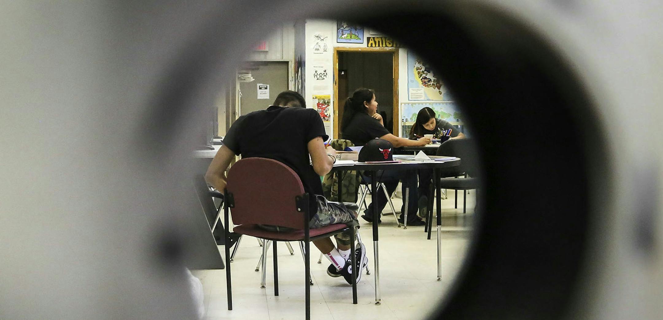Students at Bug-O-Nay-Ge-Shig High School are seen through a door hole meant for a knob. Obtaining the money for things as simple as a door knob replacement can be a complicated, difficult task at a Beareau of Indian Education school and sometimes requires going without as seen in an alternative class Wednesday, Sept. 10, 2014, in Bena, MN.](DAVID JOLES/STARTRIBUNE)djoles@startribune The Bug O Nay Ge Shig School is a culturally based alternative school that opened in 1975 with a mission of servi