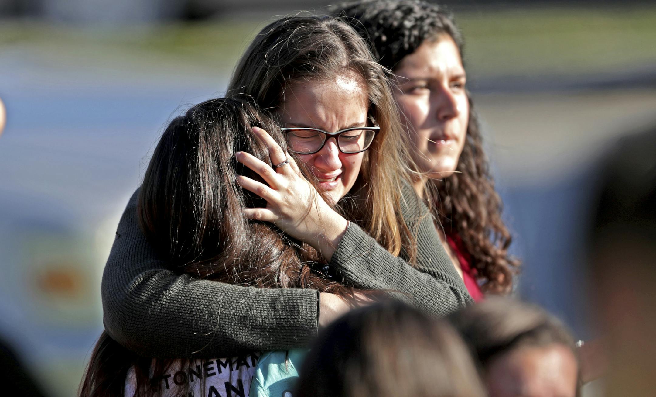 FILE - In this Wednesday, Feb. 14, 2018 file photo, students released from a lockdown embrace following following a shooting at Marjory Stoneman Douglas High School in Parkland, Fla. A week after a shooter slaughtered more than a dozen people in the Florida high school, thousands of protesters, including many angry teenagers, swarmed into the state Capitol on Wednesday, Feb. 21, calling for changes to gun laws, a ban on assault-type weapons and improved care for the mentally ill. (John McCall/So