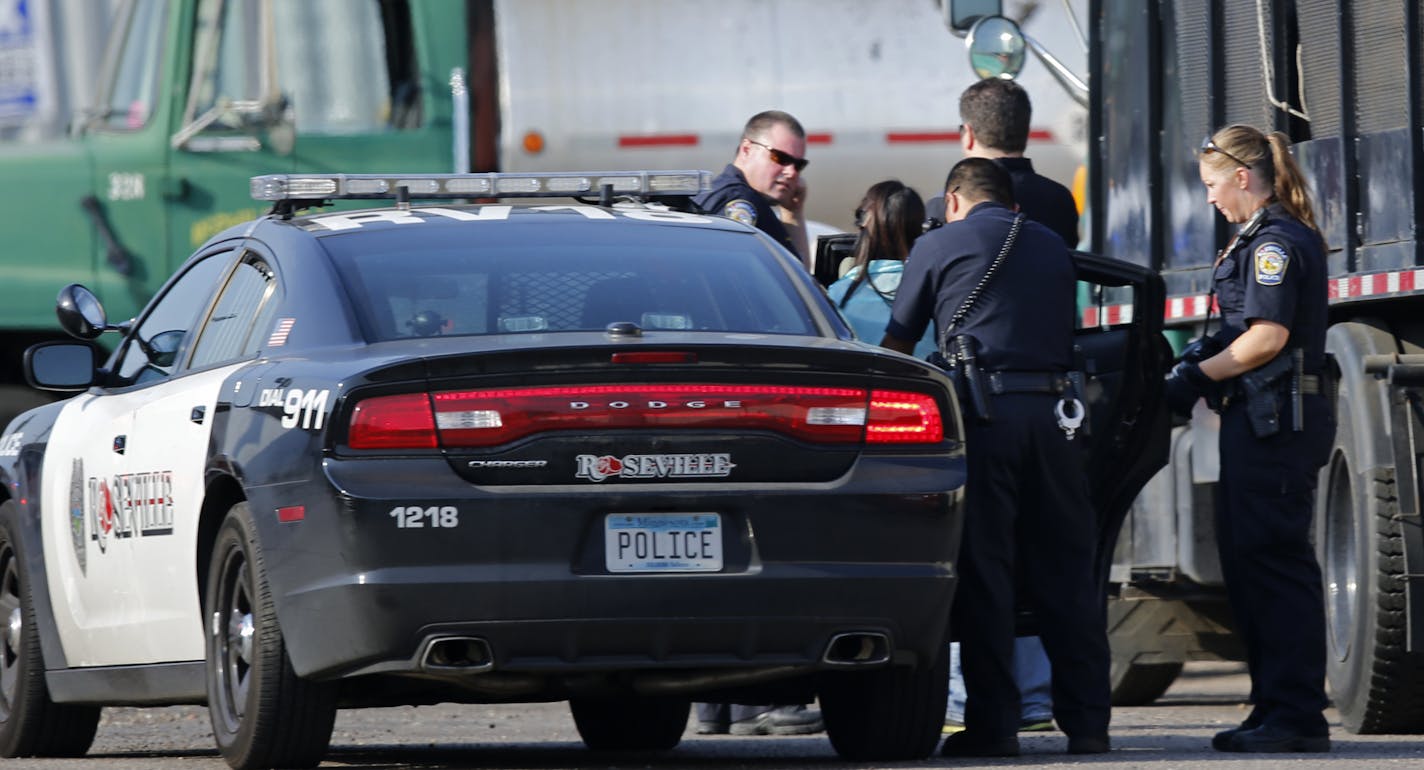 In the parking lot behind the Roseville REI, police investigated the scene of a fatal shooting where they took a woman into custody.]