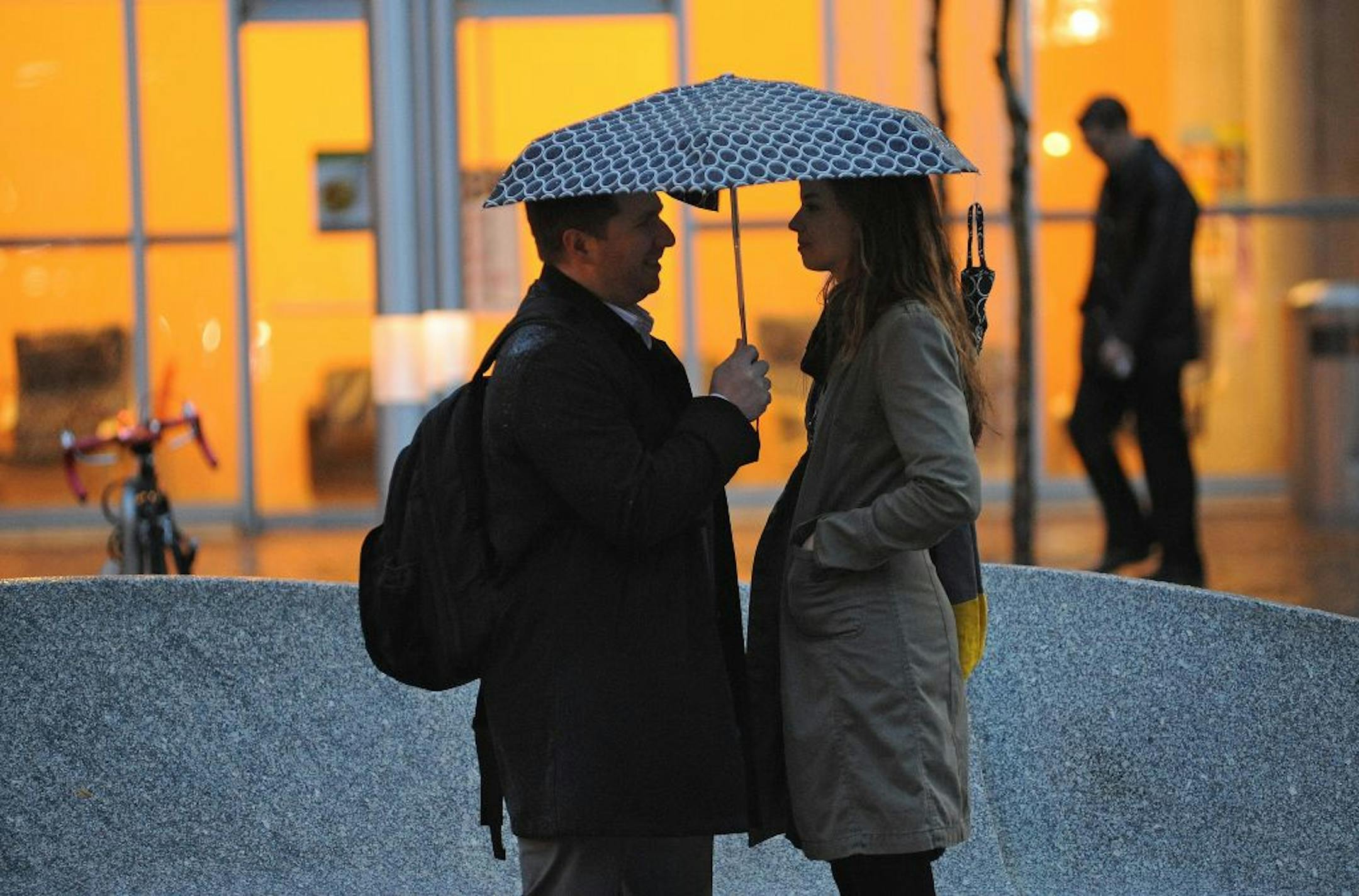 Kevin and Rebecca Robledo who are husband and wife shared an umbrella while waiting for a bus on Nicollet Ave in Minneapolis on Thursday morning October 25, 2012