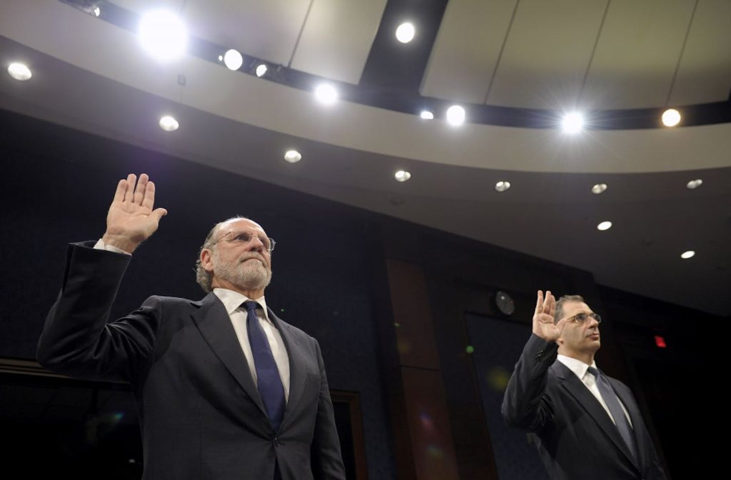 Former MF Global Holdings Ltd. Chairman and Chief Executive Officer Jon Corzine, left, and MF Global Holdings Ltd. COO Bradley Abelow are sworn in on Capitol Hill in Washington, Thursday, Dec. 15, 2011, prior to testifying before the House Financial Services Committee.