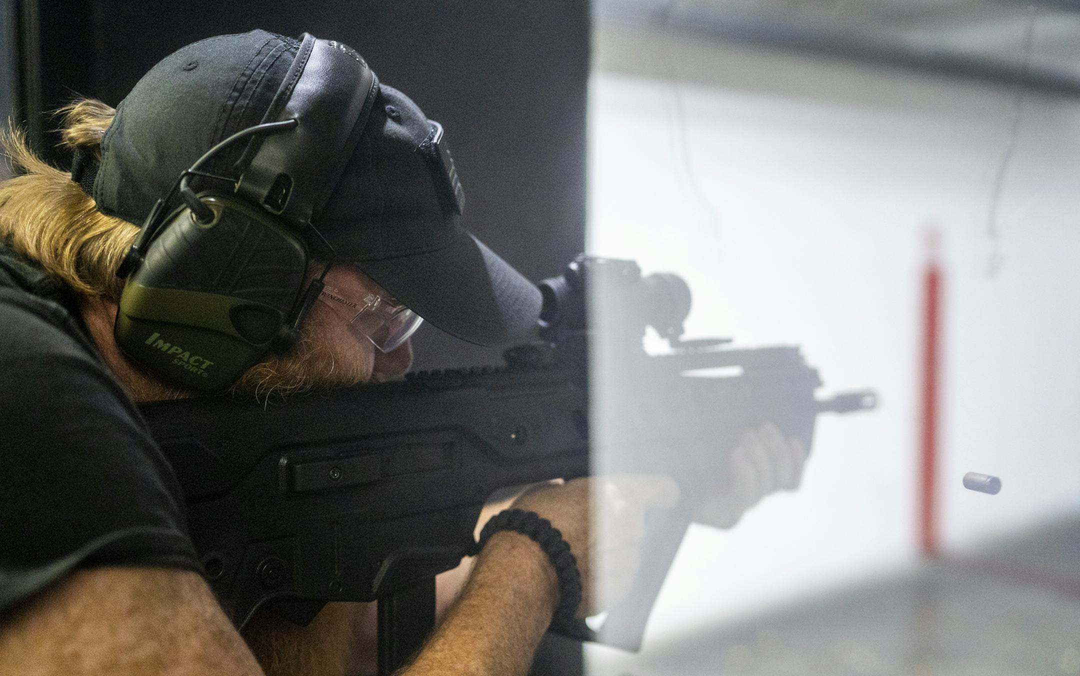 In this Dec. 1, 2018, photo, Pink Pistols member Eric Inman, an NRA-certified pistol instructor, fires an IWI Tavor at Bill's Gun Shop and Range in Circle Pines, Minn. The gun range provides safe space for LGBT gun rights group. (Evan Frost/Minnesota Public Radio via AP)
