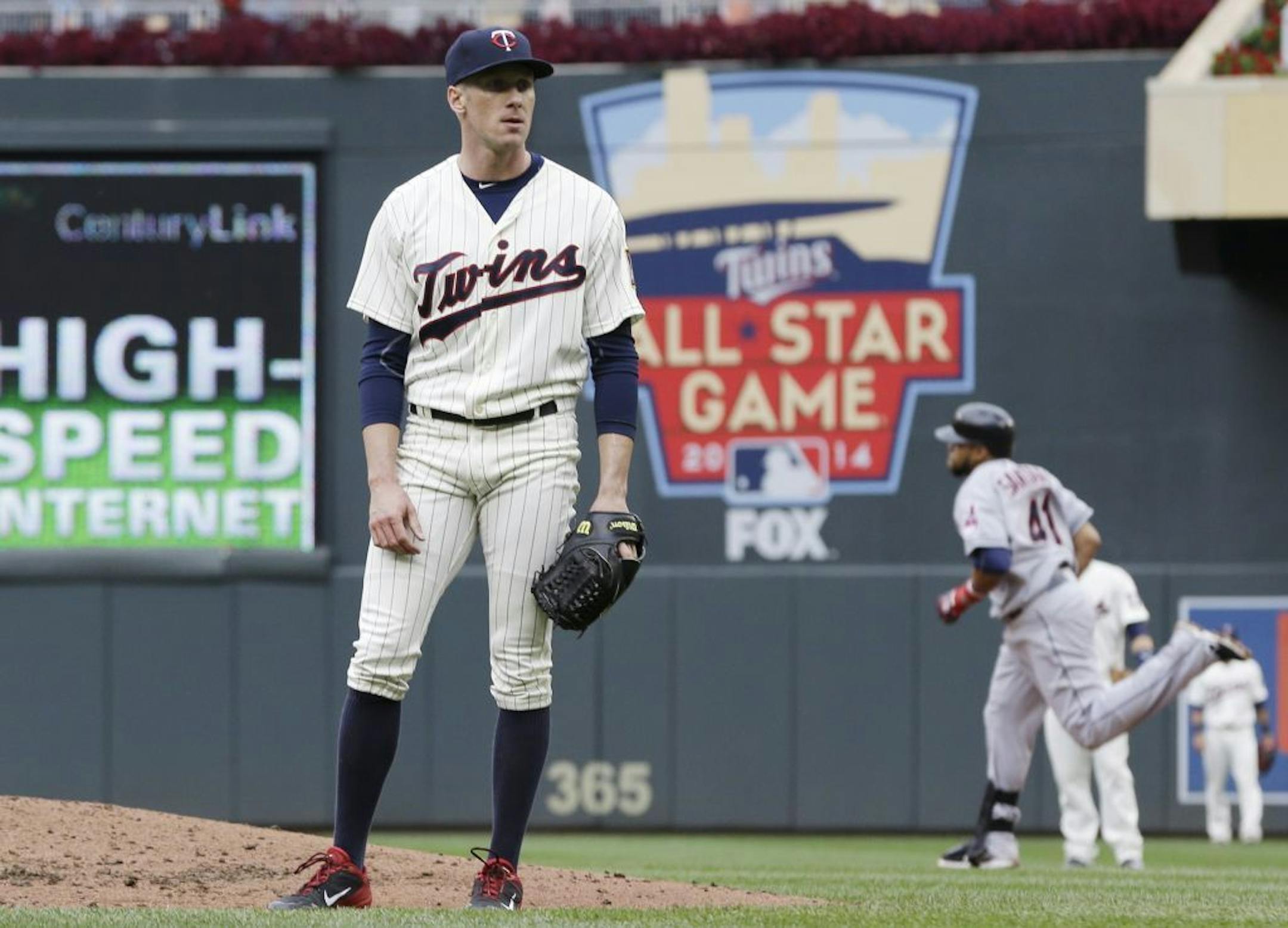Cleveland Indians' Carlos Santana (41), right, rounds the bases on a two-run home run hit off Minnesota Twins pitcher Cole DeVries, left, in the fourth inning of a baseball game on Saturday, Sept. 28, 2013, in Minneapolis.