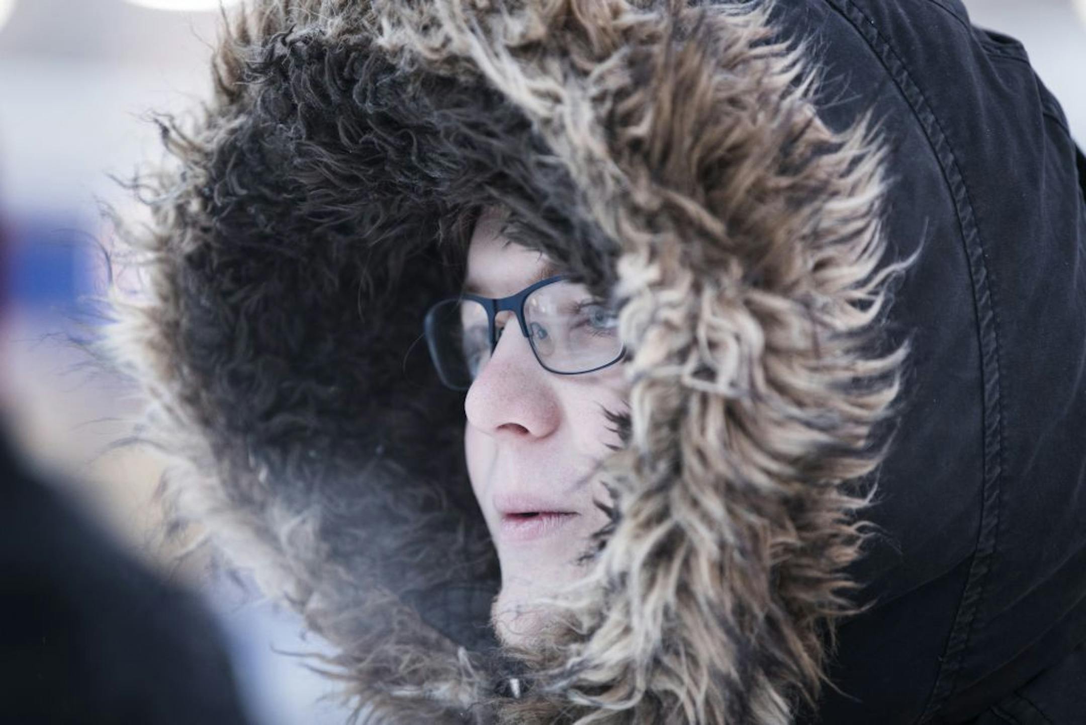 Zach Raph waits for a morning bus on Riverside Avenue in Minneapolis.
