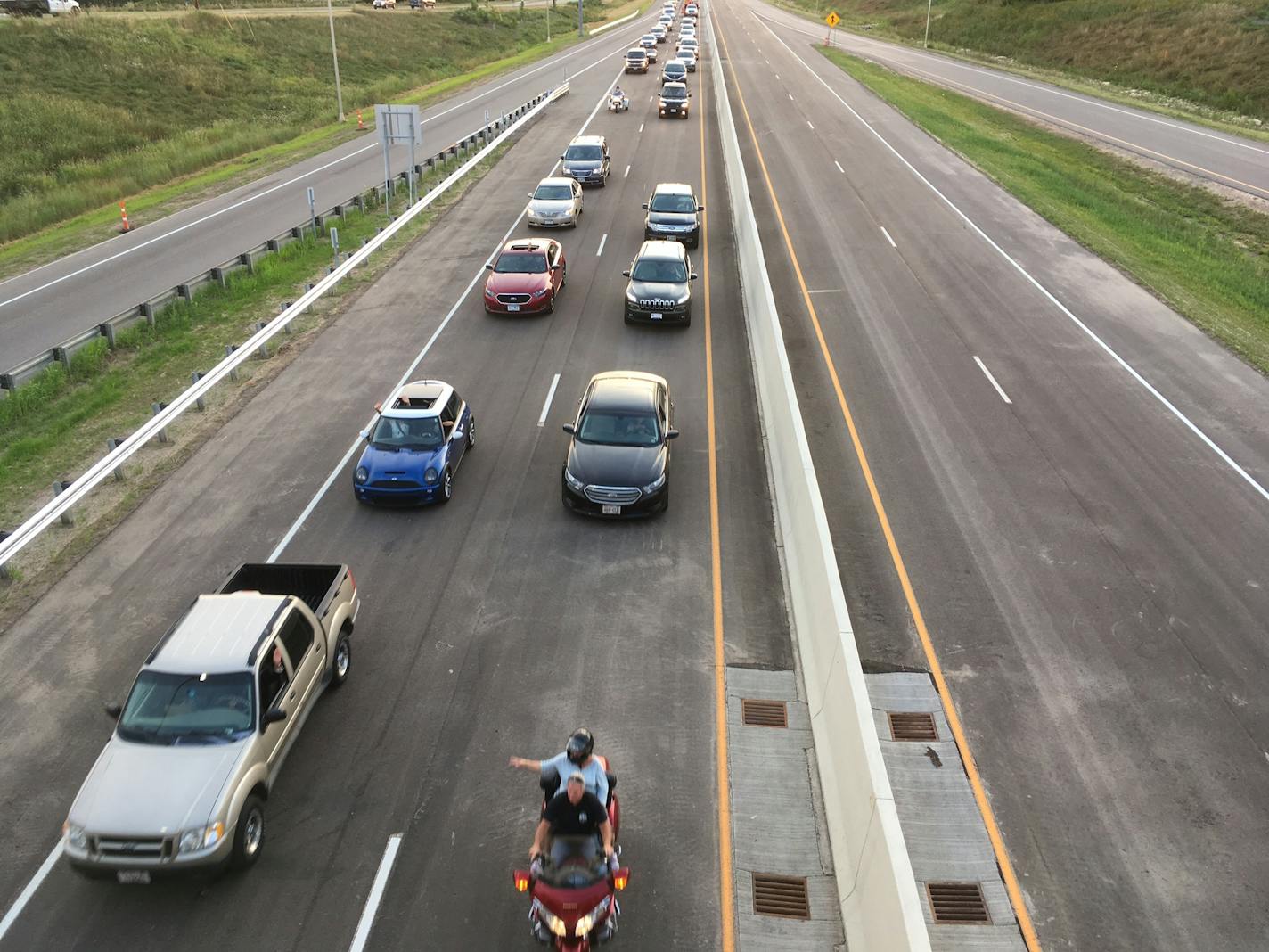 The first cars to cross the St. Croix River bridge leave Oak Park Heights on Wednesday on their way to the milelong span.