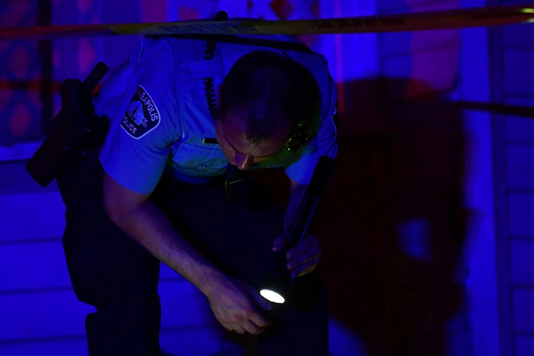 A Minneapolis Police officer used his flashlight to look for evidence near the scene of a fatal shooting near Penn Avenue North and North 21st Avenue Thursday night.