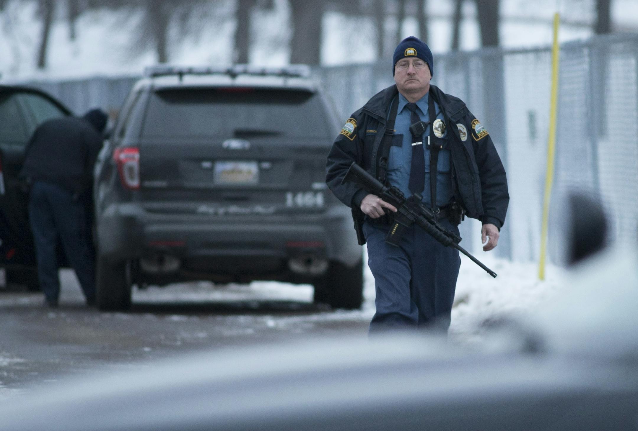 A St. Paul police officer returns to his car at the West Sycamore Street and Sylvan Street intersection in St. Paul after the end of a standoff Friday.