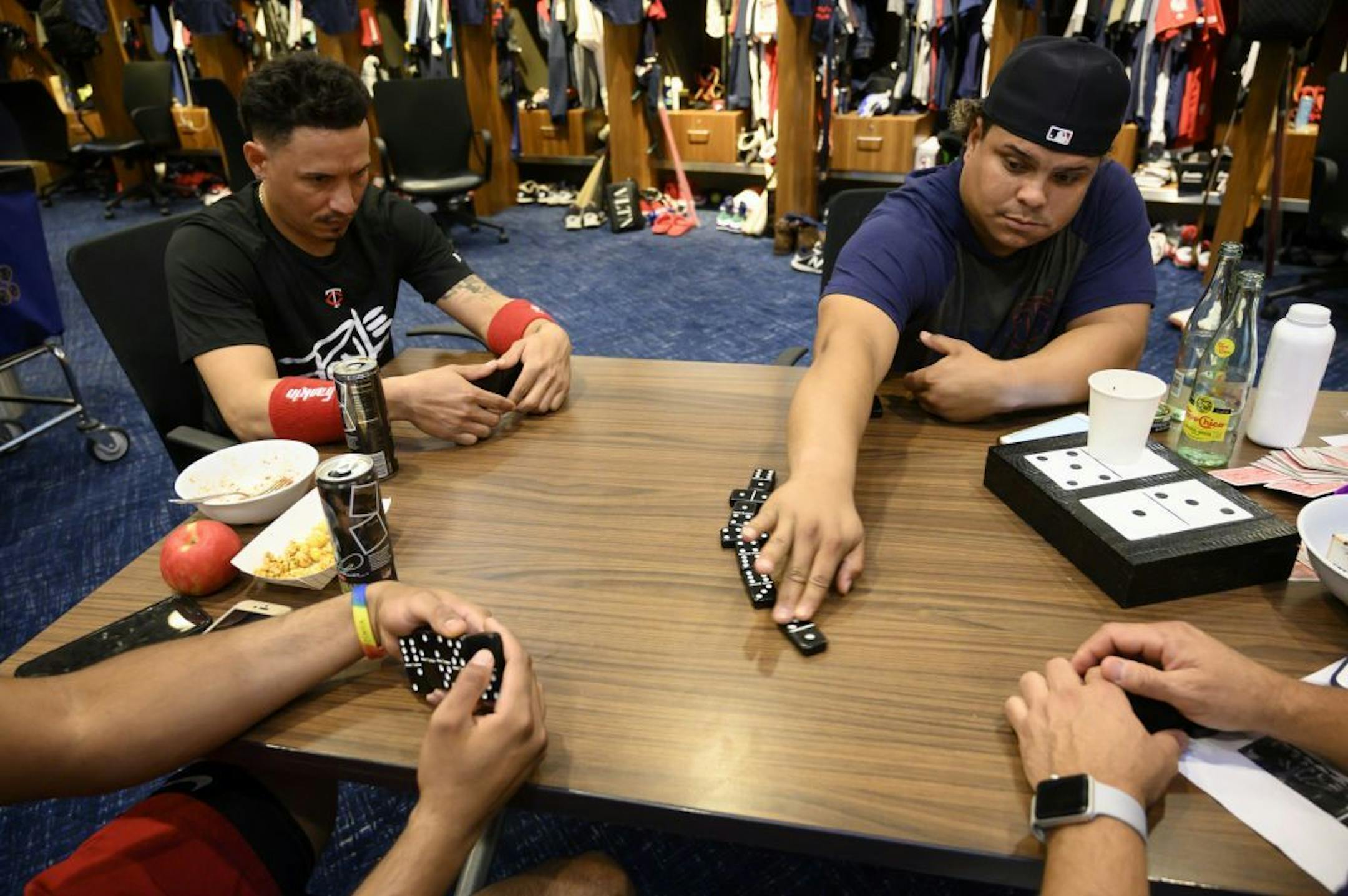 Infielder Ronald Torreyes and catcher Willians Astudillo are among a foursome playing dominoes in the clubhouse before the start of a game against the Royals on Sept. 22. Their opponents are infielder Luis Arraez and team translator Elvis Martinez.