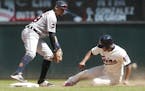 Minnesota Twins' Eduardo Escobar, right, is forced out at second by Detroit Tigers shortstop Dixon Machado on a fielder's choice in the fourth inning 