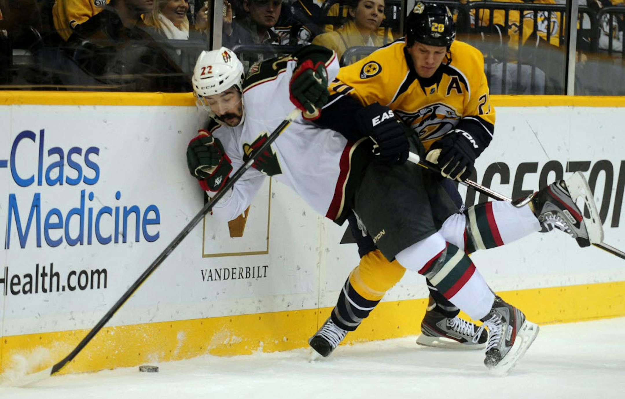 Cal Clutterbuck and Nashville's Ryan Suter (right) fight for the puck. in December 2011