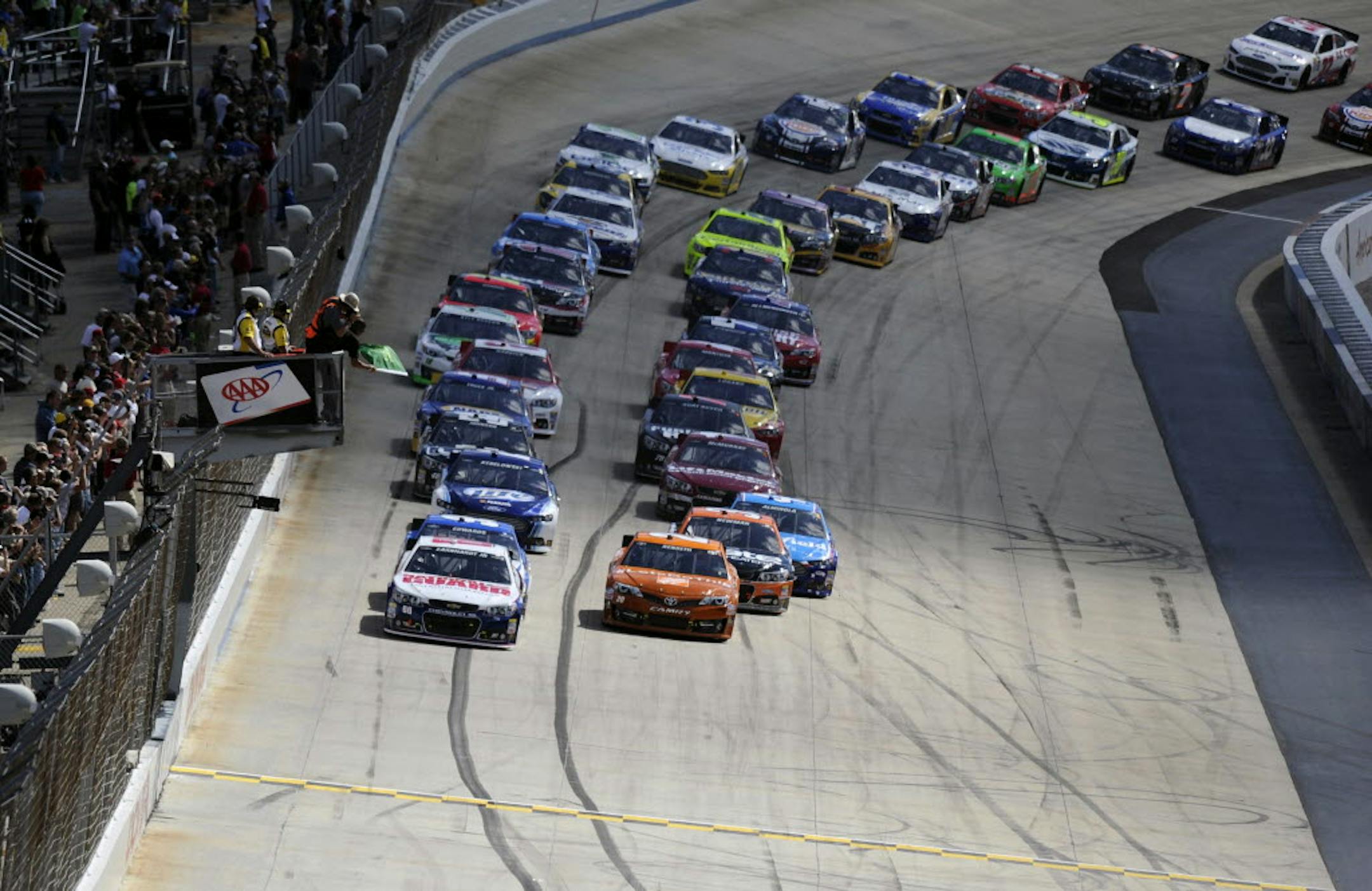 Dale Earnhardt Jr., left, Matt Kenseth, right, and others take the green flag to start Sunday's NASCAR Sprint Cup Series race on Sunday, Sept. 29, 2013, at Dover International Speedway.