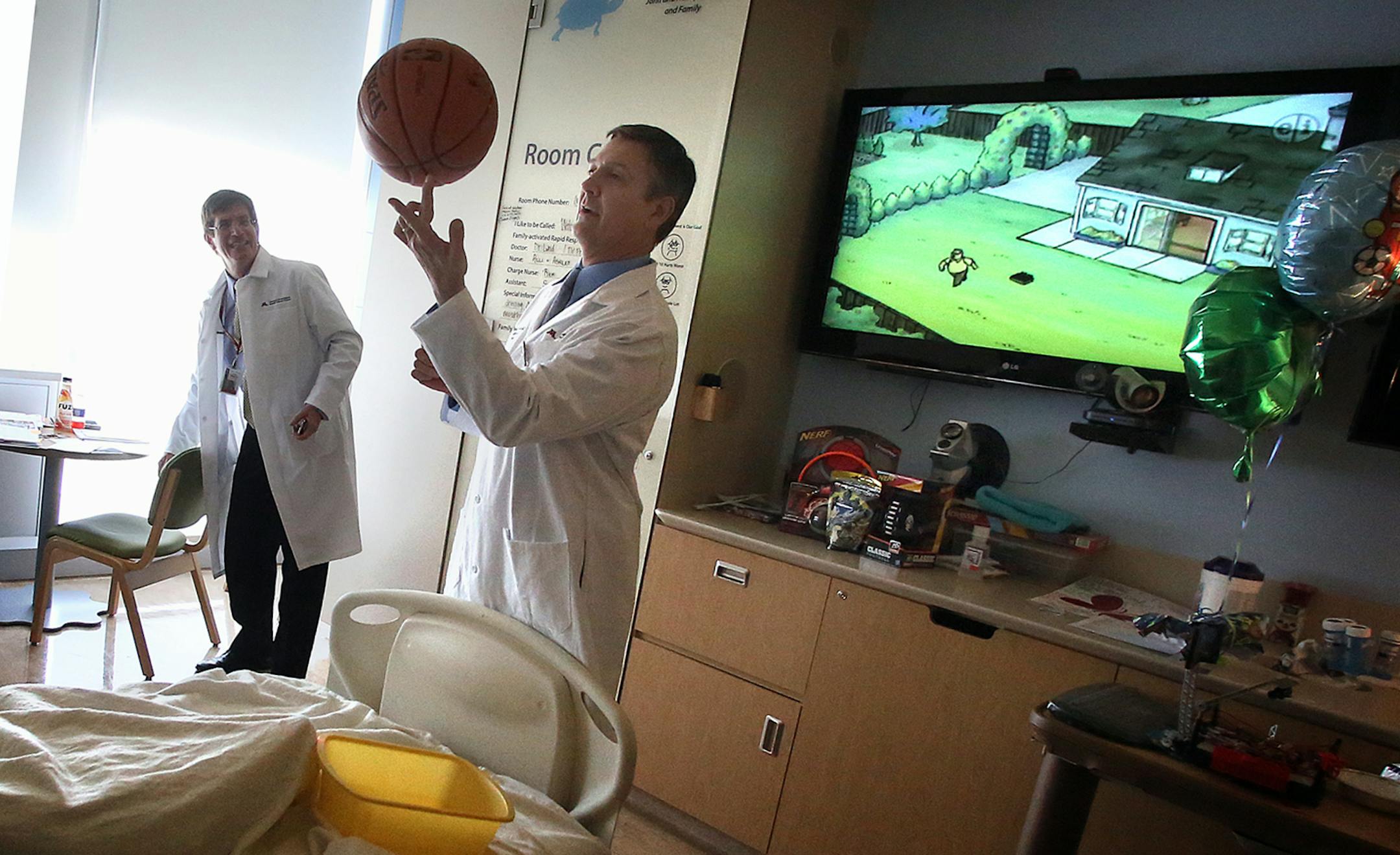 Dr. Michael Verneris playfully balanced a basketball on his finger after the transplant. Dr. John Wagner is at left. ] (JIM GEHRZ/STAR TRIBUNE) / April 23, 2013 / 12:00 PM Minneapolis, MN ‚Äì BACKGROUND INFORMATION- A child who was born with the HIV virus, received an experimental treatment in his hospital room at the University of Minnesota. It may look like he's simply getting fluids from an IV bag, but he's getting cord blood cells from a donor with a genetic resistance to HI