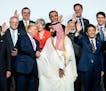 President Donald Trump shakes hands with Crown Prince Mohammed bin Salman of Saudi Arabia while posing with other world leaders for a group photo at t