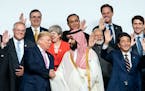 President Donald Trump shakes hands with Crown Prince Mohammed bin Salman of Saudi Arabia while posing with other world leaders for a group photo at t