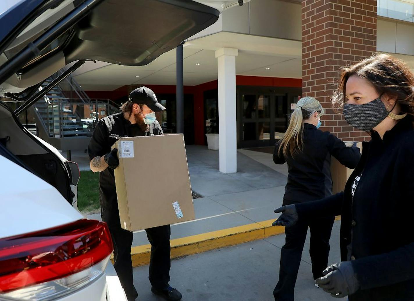 Ross Heier, Redstone Grill executive chef, left, to right, Kristin Kroeger, Redstone Grill regional manager, and Sarah Sheeley Horizontal Digital project manager, unloaded and delivered seventy-five lunches to day shift workers at Saint Therese of New Hope Friday, May 8, 2020, in New Hope, MN. The lunches were made and delivered by volunteers from Redstone Grill and Horizontal Digital.