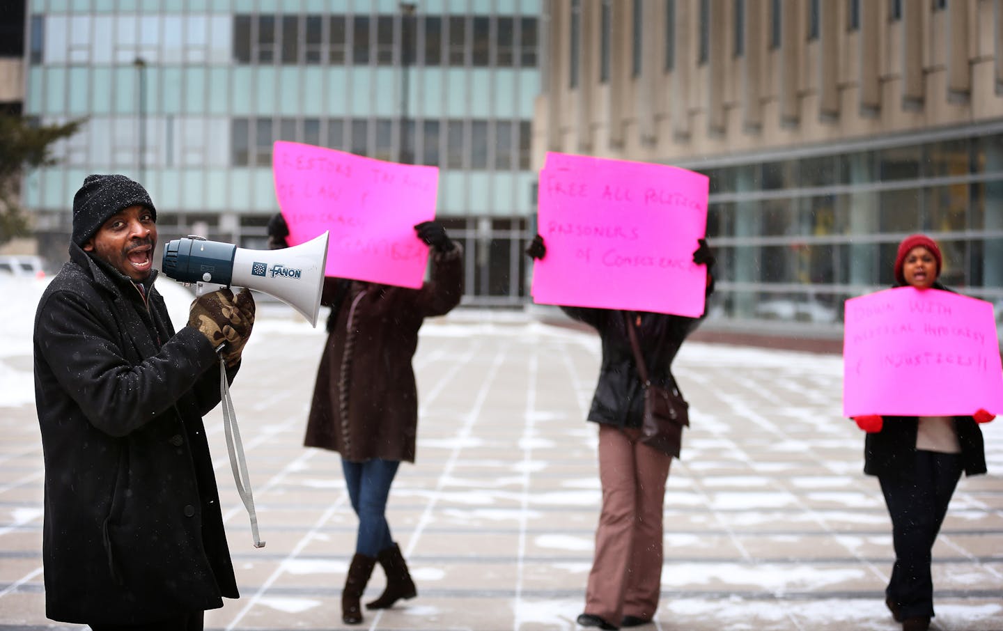 Organizer Yero Jallow, left, and other supporters of Papa Faal, a Brooklyn Park man charged with violating the federal Neutrality Act for helping plan a coup in his home country of Gambia, gather to protest in front of the Federal Courthouse in downtown Minneapolis the day of Faal's court hearing on Thursday, January 8, 2015. ] LEILA NAVIDI leila.navidi@startribune.com /