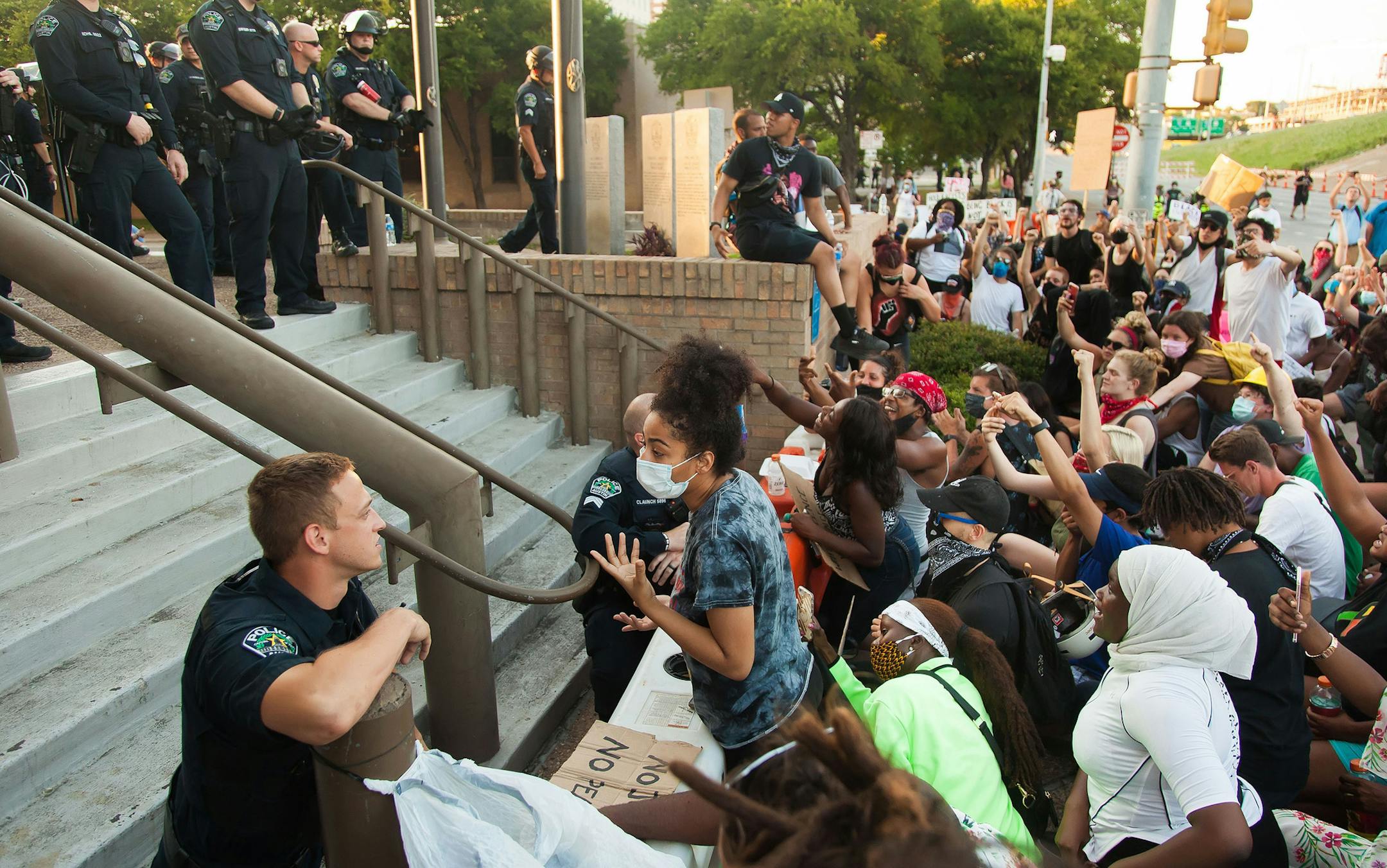 In this file photo, three police officers take a knee with the protesters. Protesters rally outside of the Austin Police Dept Headquarters in Austin, TX, to protest the deaths of Mike Ramos and George Floyd, who were killed by the police. (Leslie Spurlock/ZUMA Wire/TNS)
