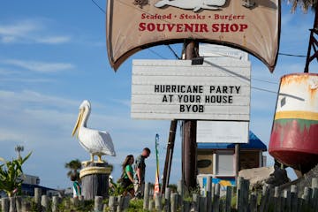 Visitors pass a restaurant closed in advance of Beryl on July 6, 2024, in Port Aransas, Texas.