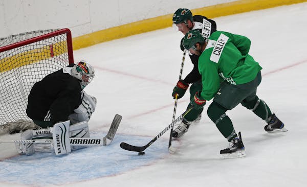 Wild forward Matt Cullen tries to get a shot on net while being defended by Gustav Olofsson during training camp.
