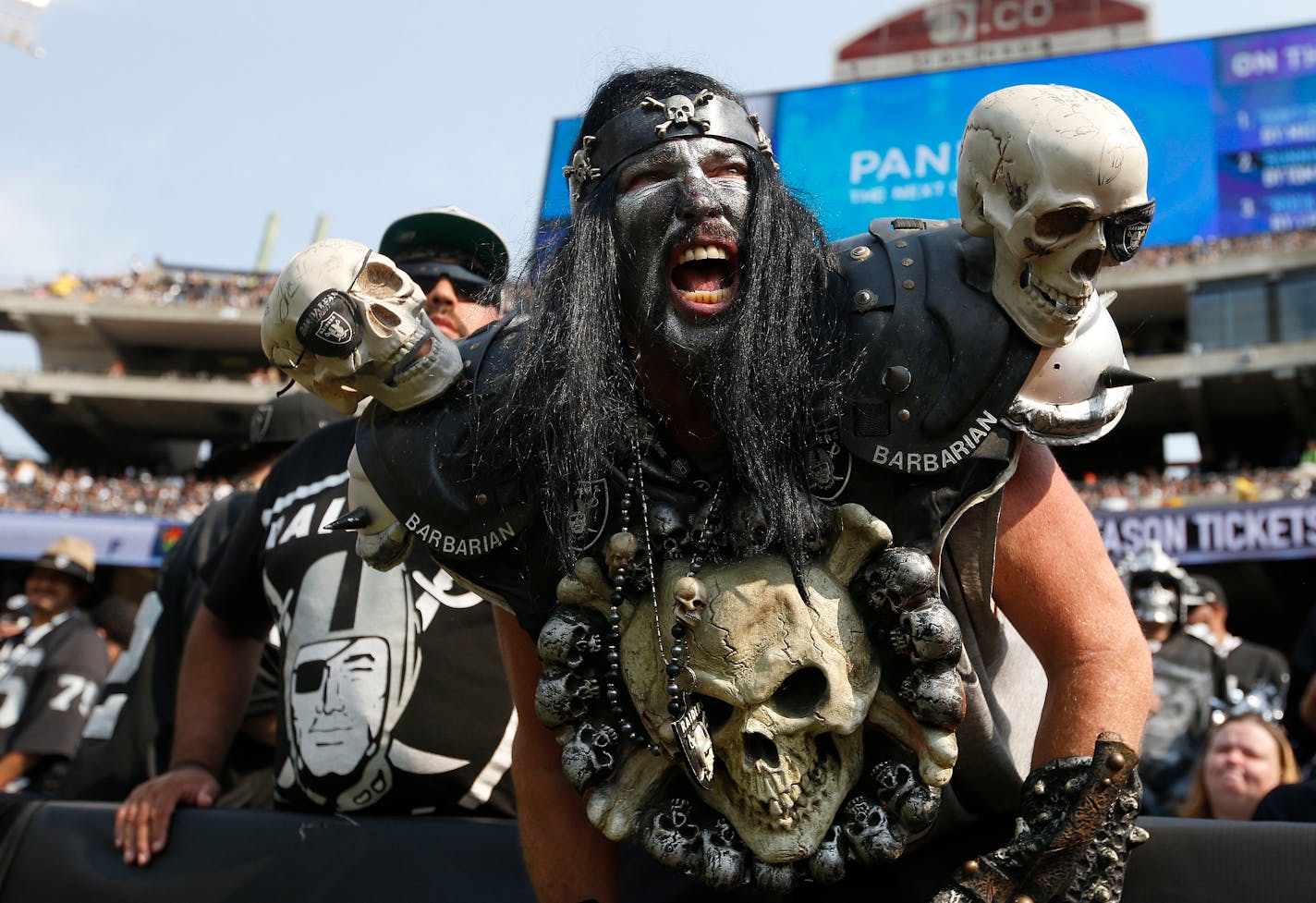 FILE - In this Sept. 13, 2015, file photo, Oakland Raiders fans watch during the second half of an NFL football game between the Oakland Raiders and the Cincinnati Bengals in Oakland, Calif. The south end zone sections, called The Black Hole, of Oakland-Alameda County Coliseum are known to have some of the rowdiest fans in American sports, face painters who dress up in evil costumes, often with spike-covered shoulder pads. The slow, agonizing demise of the Oakland Raiders will continue for at le