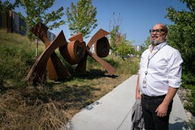 Ben Johnson, Minneapolis' first director of the new department of Arts & Cultural Affairs, looks at the sculpture "XOXO" by Karl Unnasch in northeast 