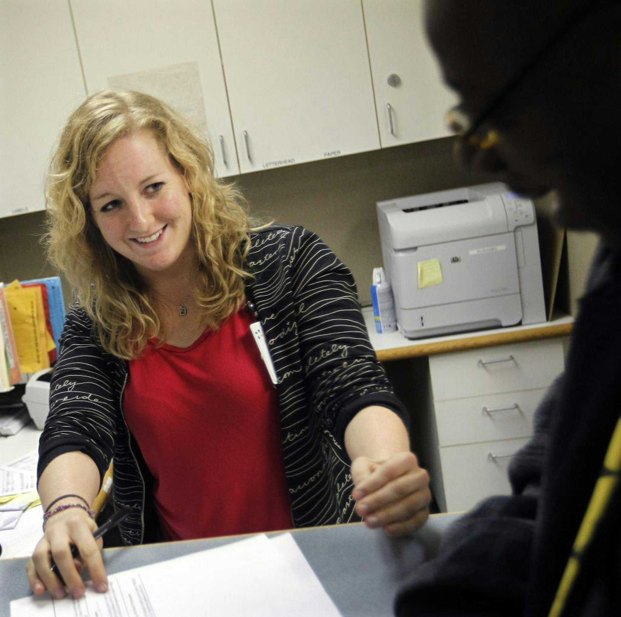 Receptionist Sarah Bruemmer made appointments for Chris Choice at the HCMC Coordinated Care Center. "I know their stories, they know mine," said Bruemmer, who said she loves seeing the repeat patients.
