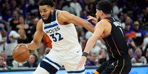 Karl-Anthony Towns drives on Suns guard Devin Booker during the first half of Game 3 in Phoenix.