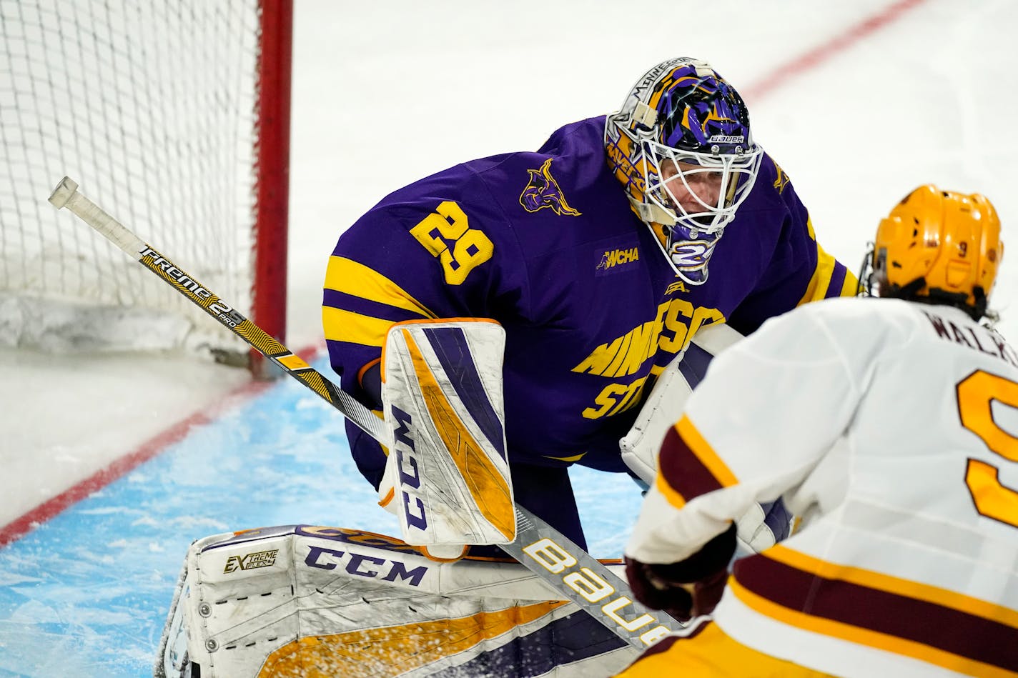 Minnesota State goaltender Dryden McKay, back, looks to stop a shot off the stick of Minnesota forward Sammy Walker in the third period of an NCAA College Hockey Regional Final, Sunday, March 28, 2021, in Loveland, Colo. (AP Photo/David Zalubowski)