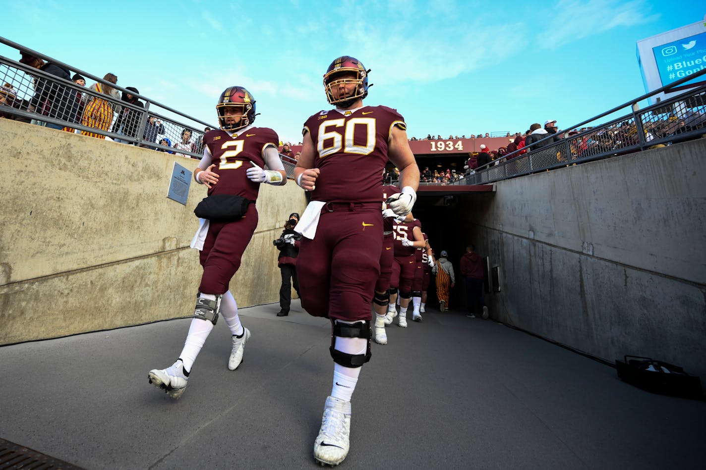 Minnesota Gophers quarterback Tanner Morgan (2) and offensive lineman John Michael Schmitz (60) jogged omnto the field before the start of an NCAA football game between the Minnesota Gophers and the Wisconsin Badgers Saturday, Nov. 27, 2021 at Huntington Bank Stadium in Minneapolis, Minn. ] AARON LAVINSKY • aaron.lavinsky@startribune.com