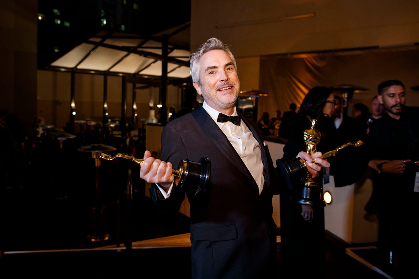 Alfonso Cuarón, holding his three Oscars for best director, best cinematography and best foreign language film for "Roma," during the Governors Ball Oscars after-party in Los Angeles, Feb. 24, 2019. (Patrick T. Fallon/The New York Times)