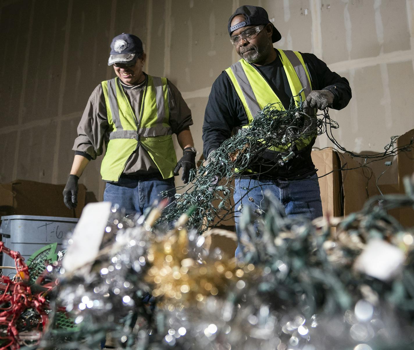 Jerry Schneider, left, and Pervis Harris sorted lights at Tech Dump in St. Paul. The lights wrap around cylindrical screens at the start of the sorting process and must be frequently removed.