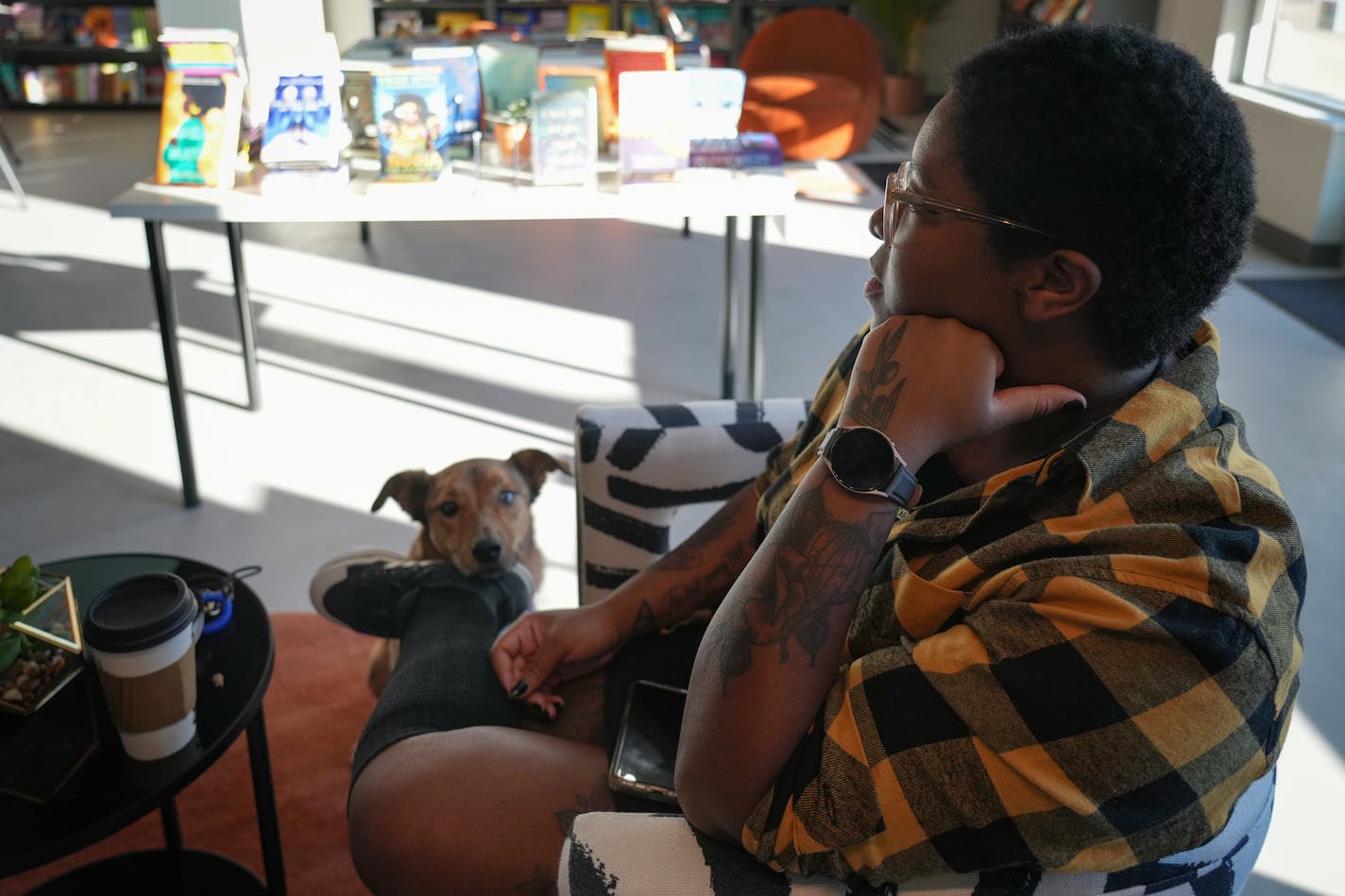 Store owner Dionne Sims and Nova the dog sit for an interview inside Black Garnet Books on Small Business Saturday in St. Paul, Minn., on Saturday, Nov. 26, 2022. ] SHARI L. GROSS • shari.gross@startribune.com