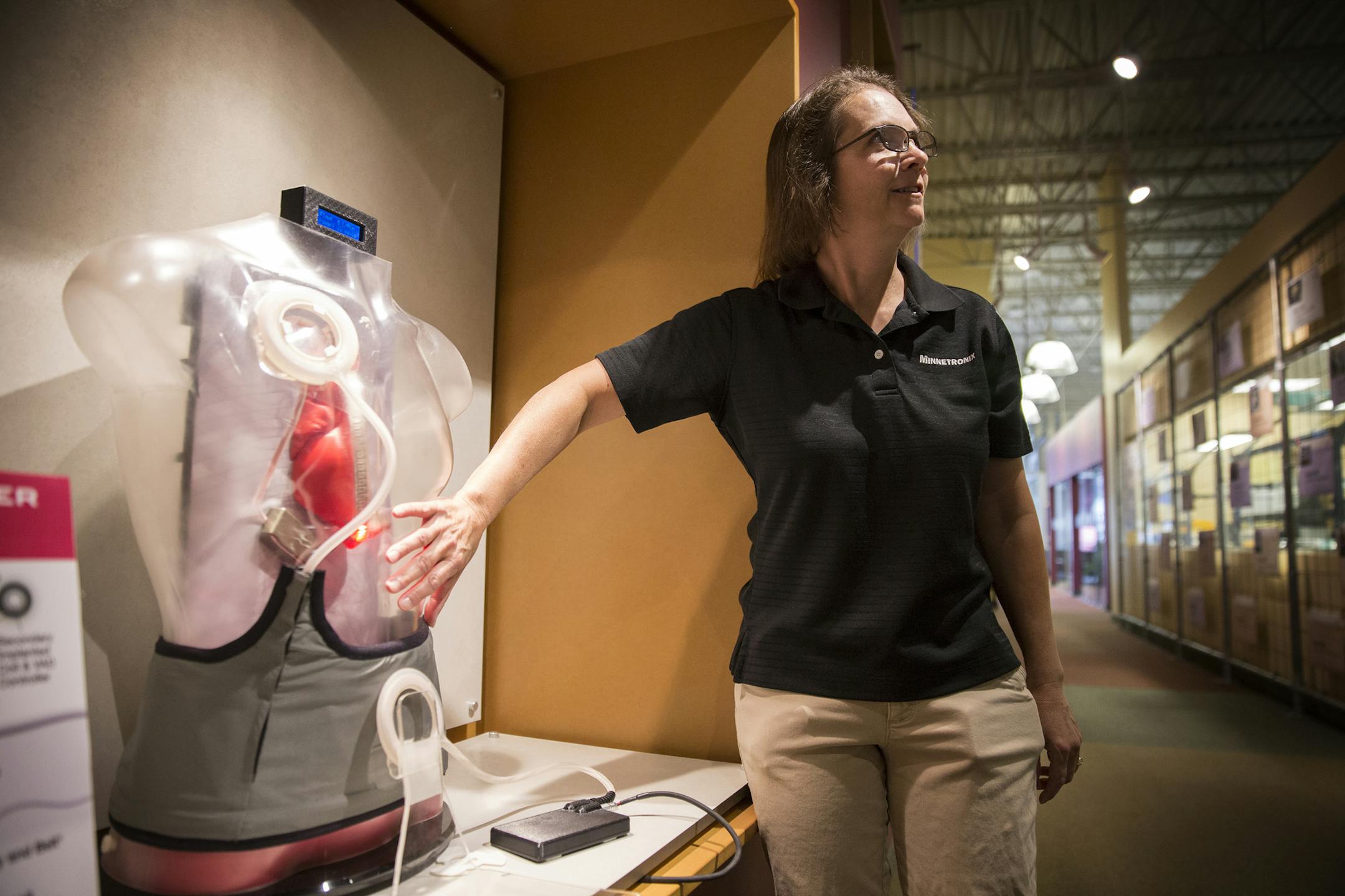 Lori Lucke, a systems engineer fellow with Minnetronix, explains the TETS (Transcutaneous Energy Transmission System), a wireless power transfer system used to run an LVAT (Left Ventricular Assist Device), or heart pump, on display at Minnetronix in St. Paul on Wednesday, August 5, 2015. ] LEILA NAVIDI leila.navidi@startribune.com / BACKGROUND INFORMATION: Minnetronix is marketing a new technology that allows the batteries in implantable medical devices to be recharged wirelessly. The technology