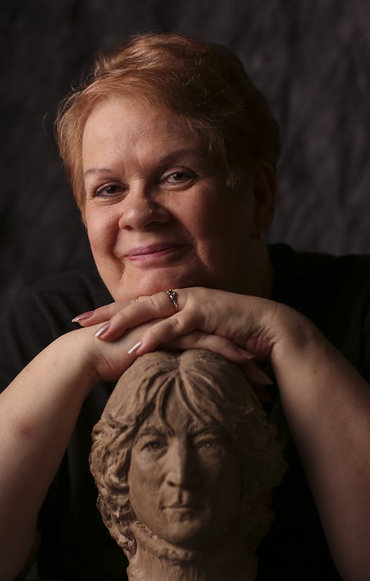 Kathy Burns with a bust of John Lennon.
