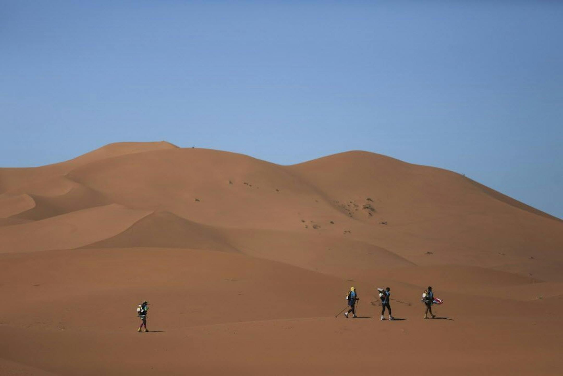 Competitors cross sand dunes as they take part in the final stage of the 33rd edition of Marathon des Sables during a sandstorm in the Sahara desert, near Merzouga, southern Morocco, Wednesday, April 14, 2018.