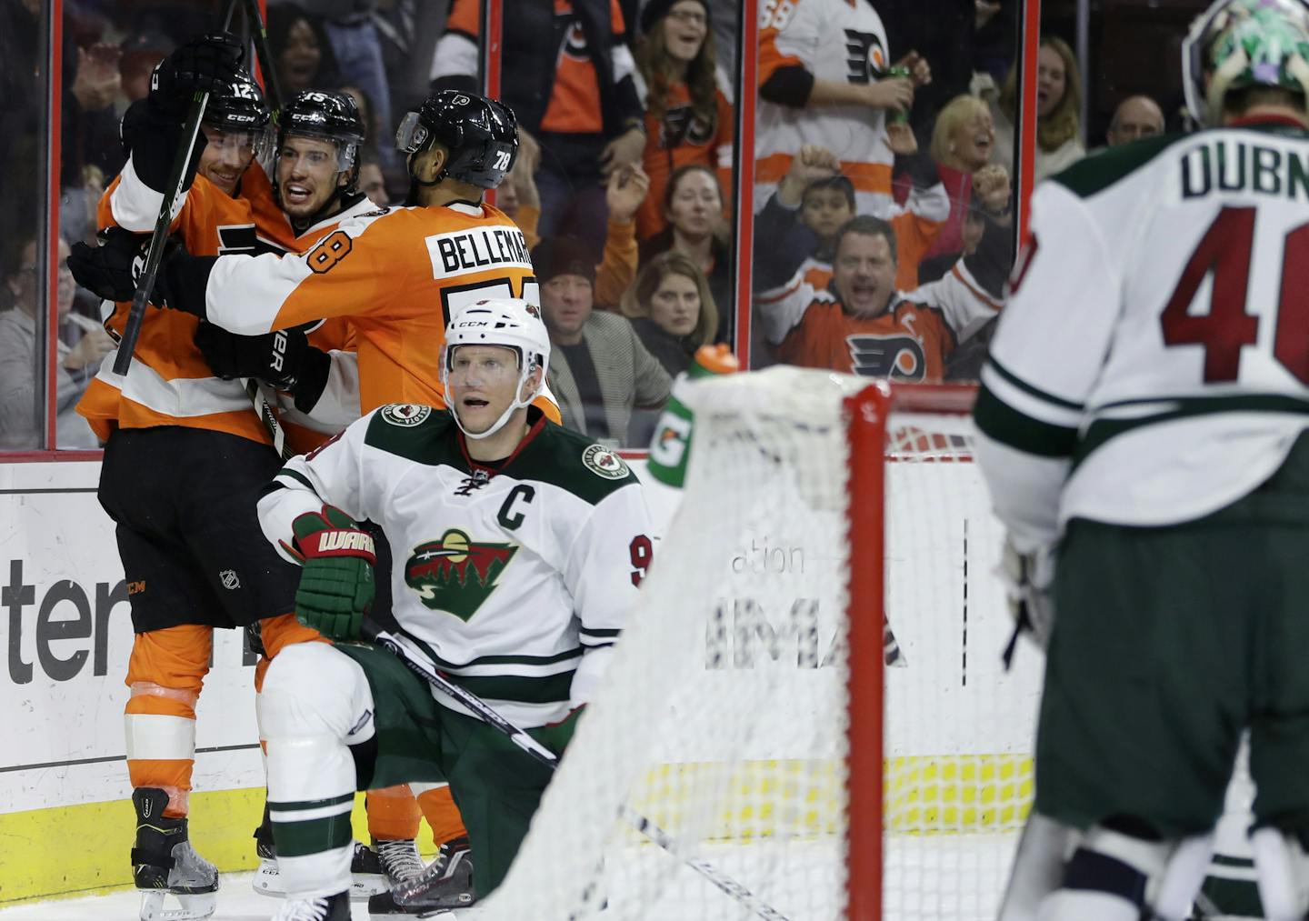 Philadelphia Flyers' Michael Raffl (12), Michael Del Zotto (15) and Pierre-Edouard Bellemare (78) celebrate Del Zotto's goal, near Minnesota Wild's Mikko Koivu (9) and Devan Dubnyk (40) during the second period of an NHL hockey game, Saturday, Nov. 12, 2016, in Philadelphia. (AP Photo/Matt Slocum)