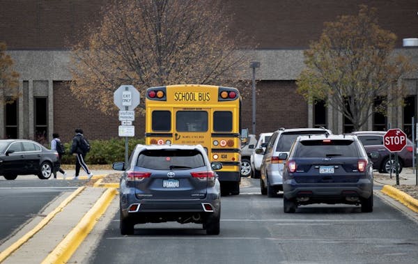 A police vehicle pulled up to Bloomington Jefferson High School while cars waited to pick students.