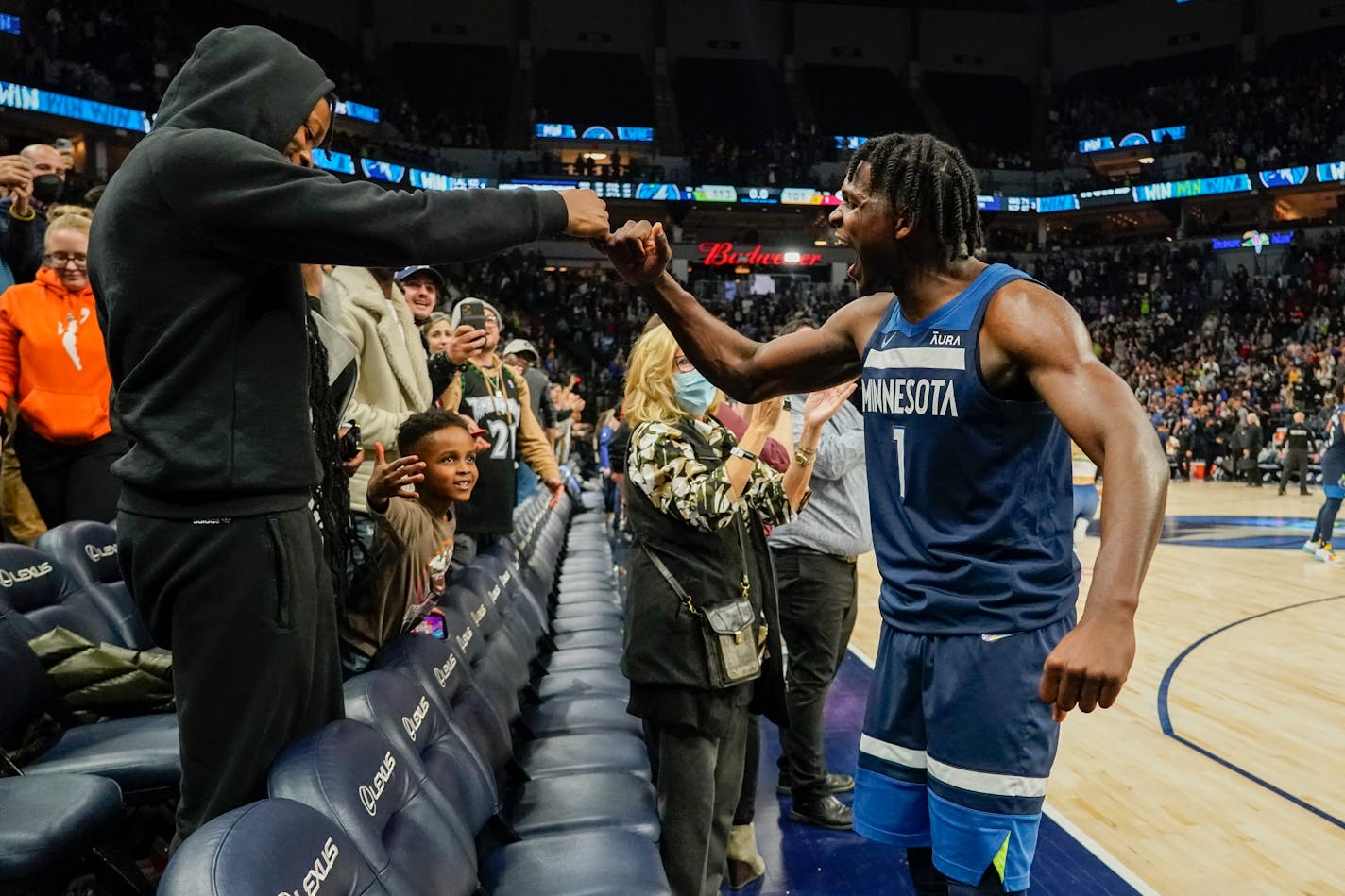 Minnesota Timberwolves guard Anthony Edwards celebrated with a fan after defeating the Miami Heat 113-101 during an NBA basketball game Wednesday, Nov. 24, 2021, in Minneapolis. Edwards scored 33 points in the game. (AP Photo/Craig Lassig)