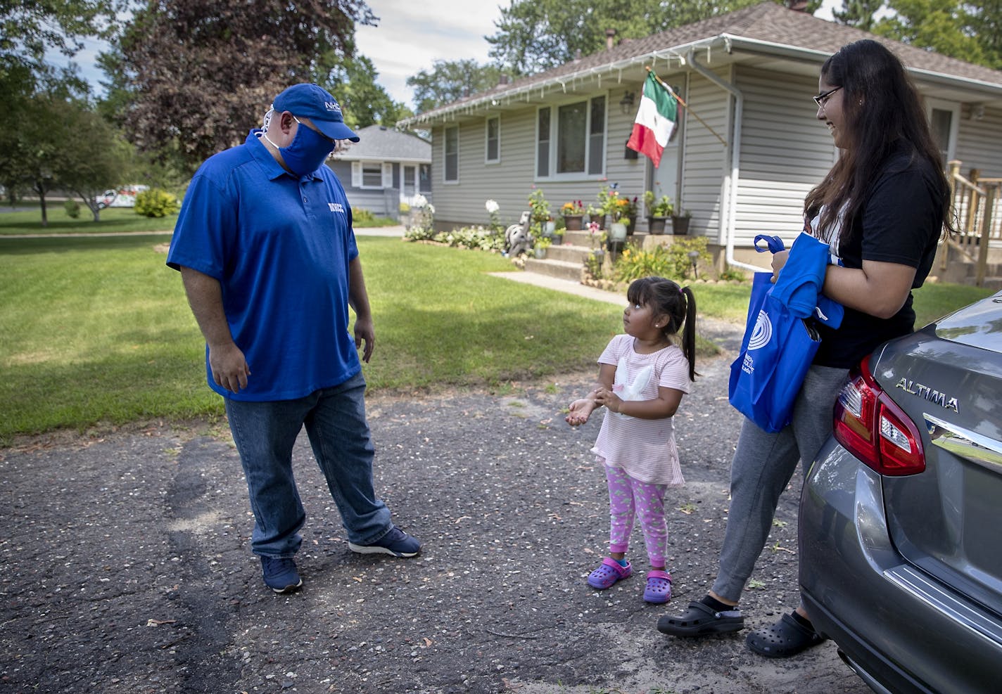 North Hennepin Community College President Rolando Garcia made a home visit with new student Danna Dominguez, right, and her little sister Rebecca Dominguez, as he delivered welcome bags to new students, Wednesday, July 29, in Brooklyn Park, MN.