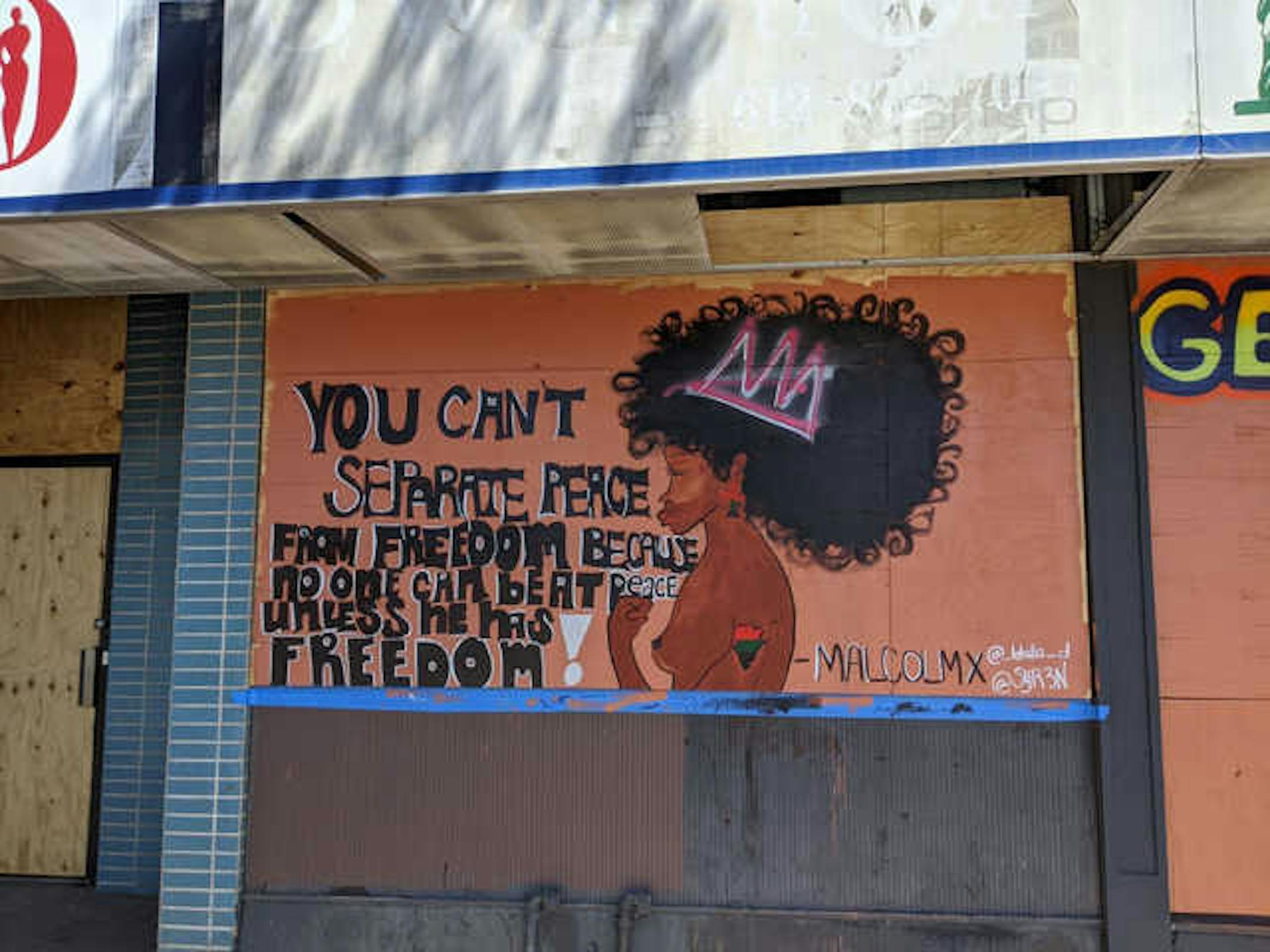 In the days following the death of George Floyd by Minneapolis police, artists paint a mural on Talk of the Town Salon, 2403 Nicollet Ave., that references a Malcolm X.