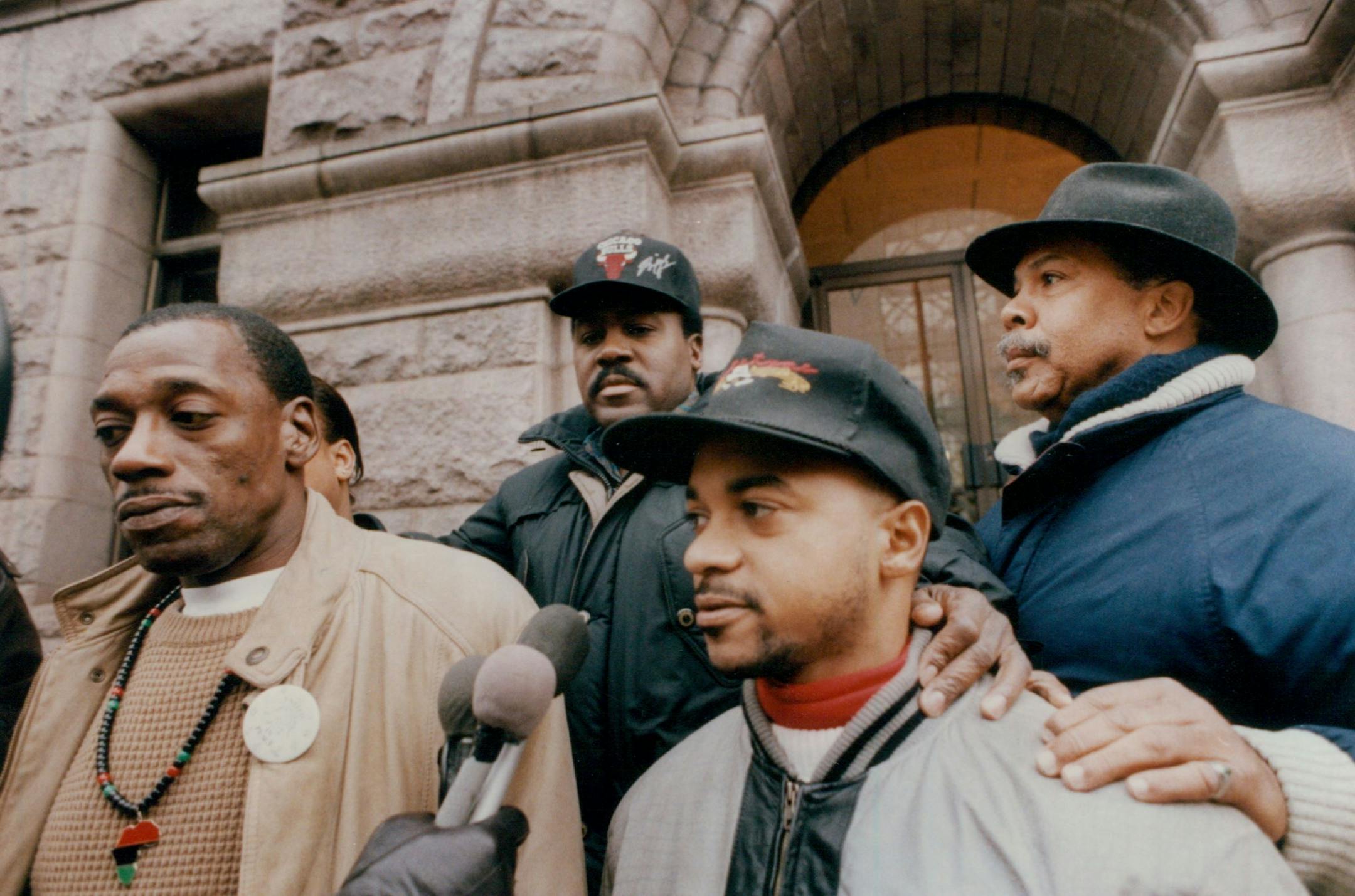 November 24, 1992 Mwati McKenzie, a suspect in the Jerry Haaf slaying, turned himself in to Mpls police. Group from united for peace met with media after McKenzie turned himself in.... left to right....Sharif Willis, (no hat), Spike Moss, with City, Inc., (back row baseball cap), Rev. Jerry McAfee, (baseball cap, light jacket) and Ron Edwards, (back row far right).. .a black activist, radio announcer. Meeting was on the steps of City Hall. November 25, 1992 John Croft, Minneapolis Star Tribune
