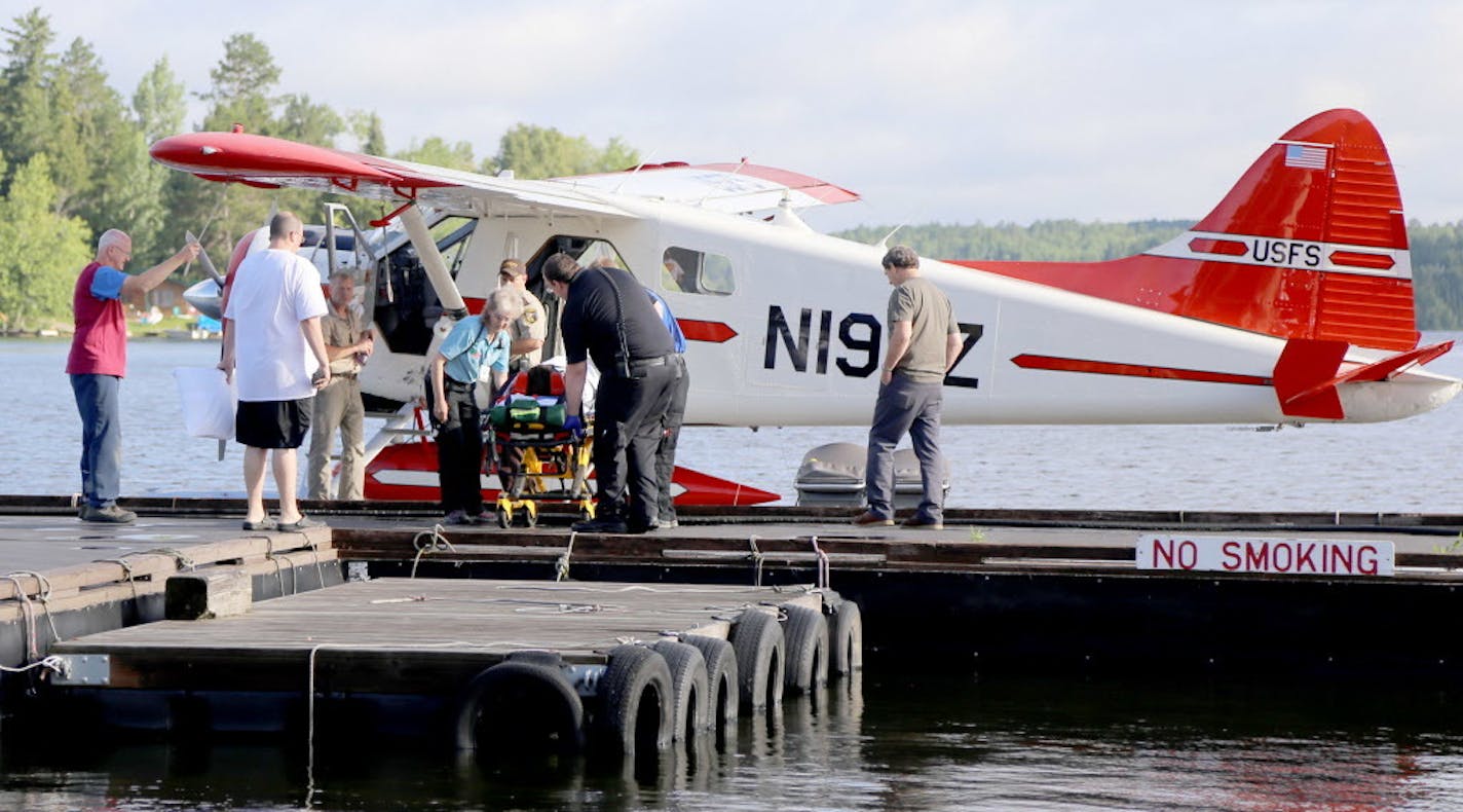 A camper is attended to by ambulance staff after arriving Thursday, July 21, 2016 in Ely, Minn., by floatplane from the Boundary Waters Canoe Area Wilderness after being injured following a severe storm that knocked trees down on Basswood Lake. The injured party received non-life threatening injuries and was treated at the Ely-Bloomenson Community Hospital. A boy and a woman camping with a Boy Scouts adventure program were killed and two other campers were injured when severe storms swept throug