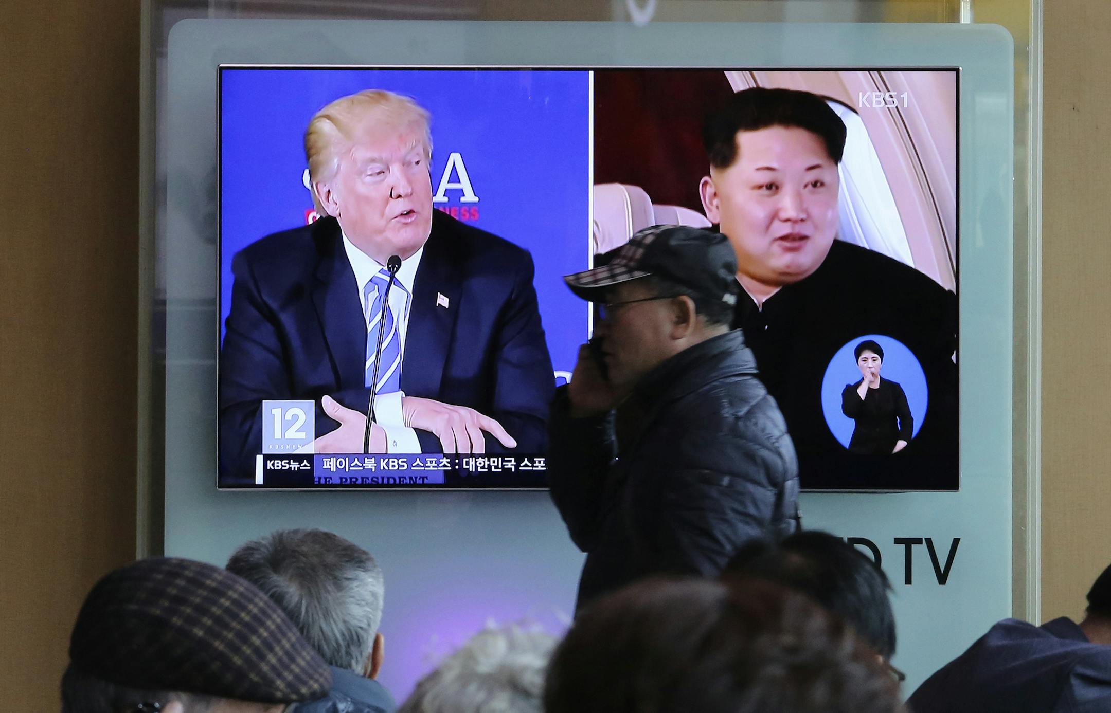 A man passes by a TV screen showing file footage of U.S. President Donald Trump, left, and North Korean leader Kim Jong Un during a news program at the Seoul Railway Station in Seoul, South Korea, Monday, April 9, 2018. North Korea's government has communicated with the United States to say that leader Kim is ready to discuss his nuclear weapons program with Trump, officials said Sunday, increasing the likelihood that the unprecedented summit will actually occur. (AP Photo/Ahn Young-joon)