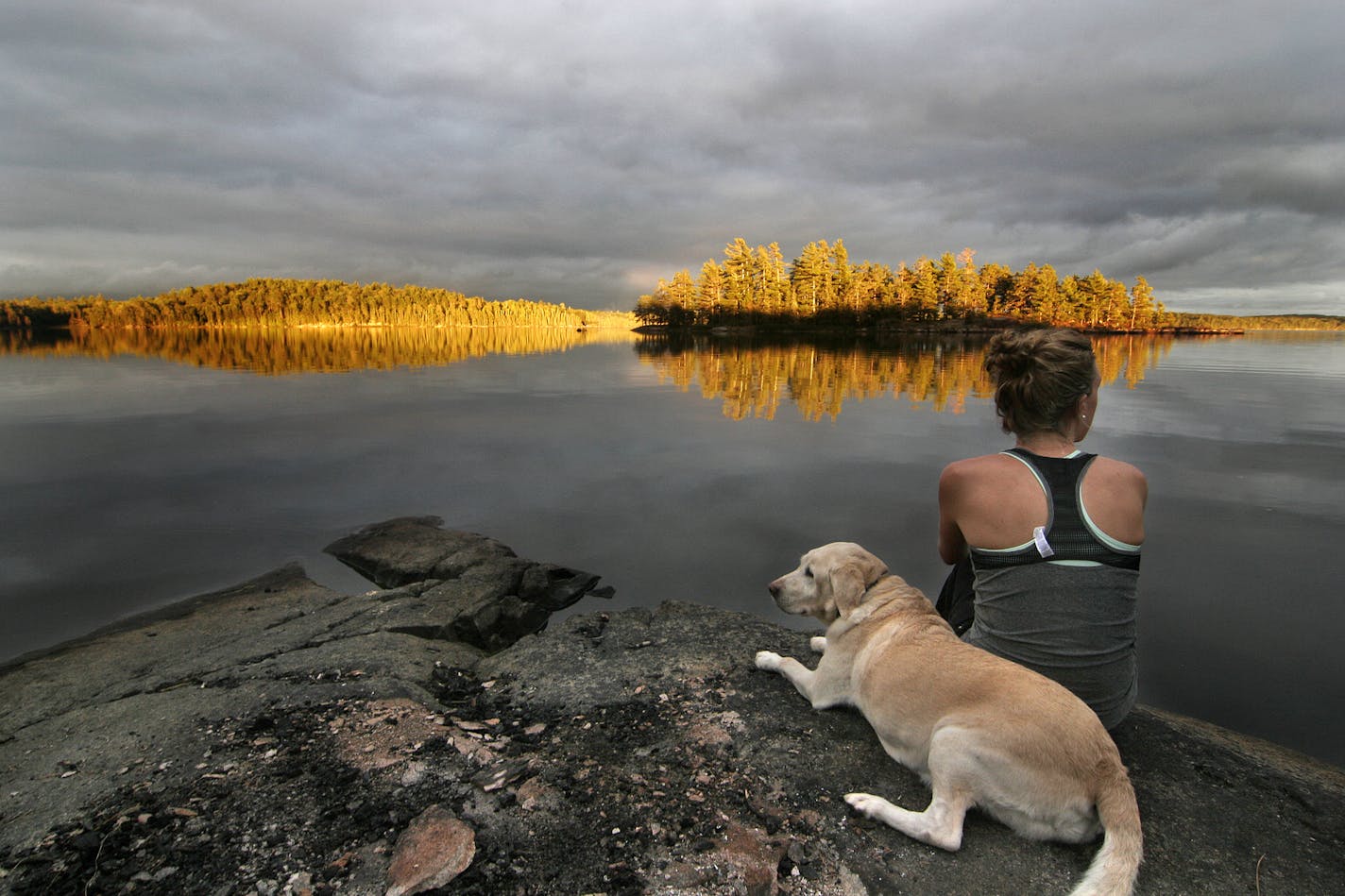 Megan Smith and her yellow Lab, Macy, enjoy a spectacular sunset on a BWCA lake.