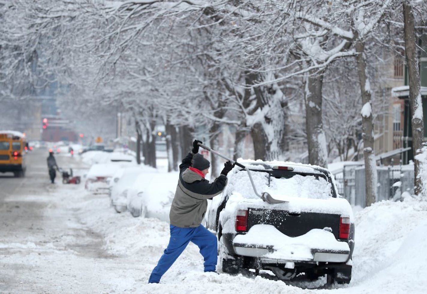 Mike Hutton clears his car of snow with a snow shovel on Park Avenue in Minneapolis.