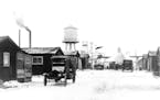 February 6, 1924 MINNESOTA HISTORICAL SOCIETY Main Street at Milford location and lake which flooded mine. St. Louis County, Buildings and Residences 