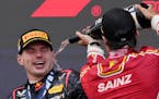 Third place Ferrari driver Carlos Sainz sprays champagne on Red Bull driver Max Verstappen in Japan on Sunday.